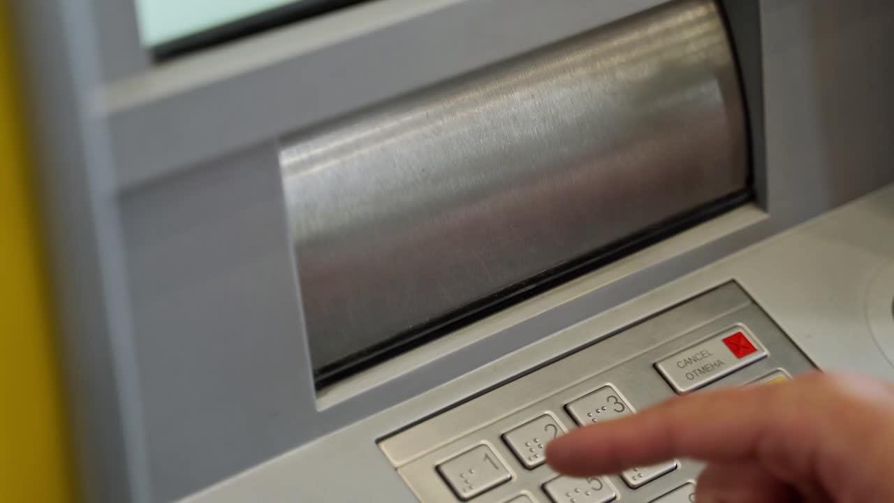 close-up of a man's hand puts a wad of cash into the receiving slot of an ATM. The dispenser closes after receiving the money. depositing paper money into an ATM. replenishment of the account in cash