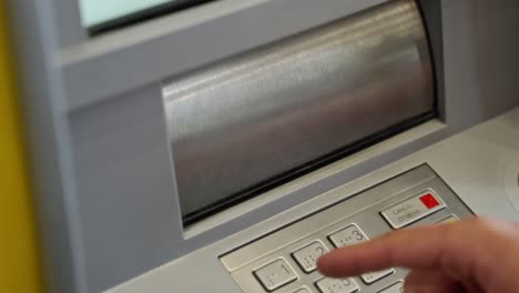 close-up of a man's hand puts a wad of cash into the receiving slot of an atm. the dispenser closes after receiving the money. depositing paper money into an atm. replenishment of the account in cash