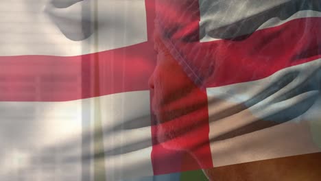 bandera de inglaterra ondeando contra caucásico cirujano masculino sénior mirando por la ventana en el hospital