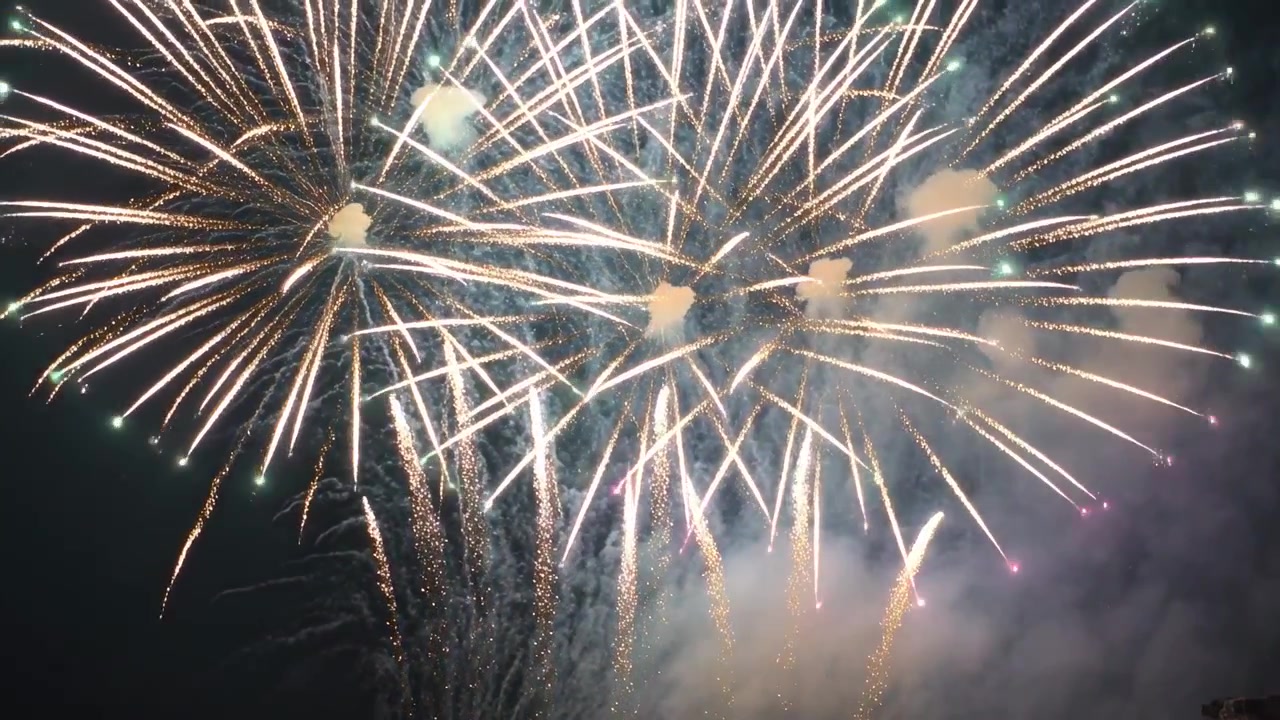 Lancio di fuochi d'artificio, uno spettacolo pirotecnico che forma esplosioni e scintille dorate nel cielo notturno, celebrando un evento