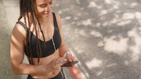 vista frontal de una mujer afroamericana usando un teléfono móvil en la ciudad 4k