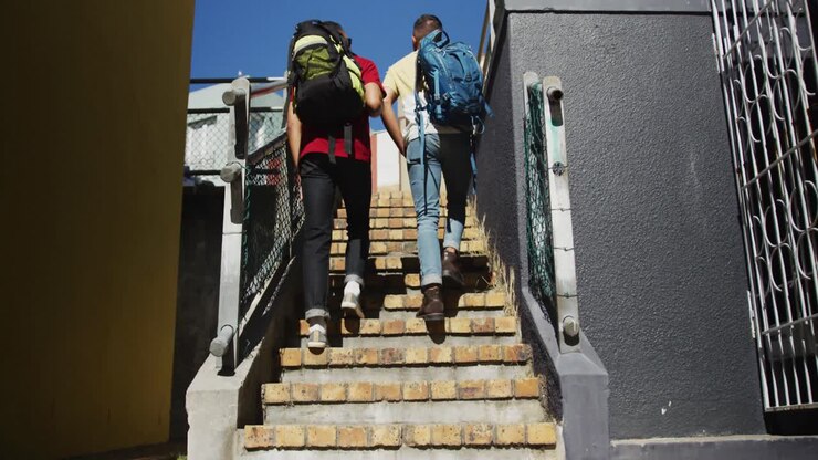 Set bagfra: To mandlige venner af blandet etnicitet går op ad trappen og snakker.