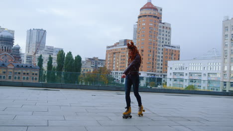 stylish woman making steps on roller skates on street. roller skater dancing.