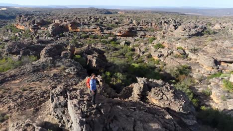 male rock climber standing over a rocky mountain 4k