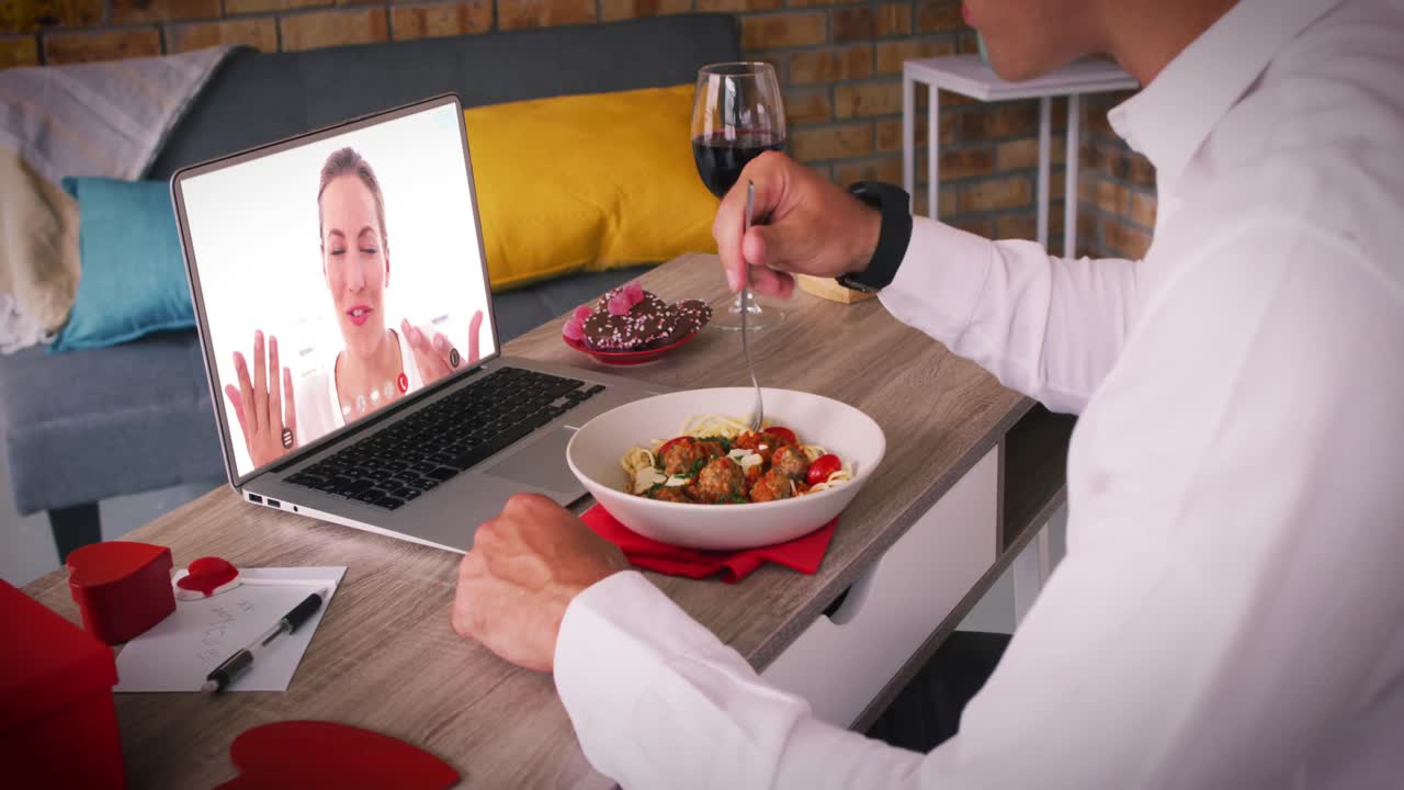 pareja caucásica en una cita de san valentín videollamada mujer en la pantalla de la computadora portátil saludando hombre comiendo comida