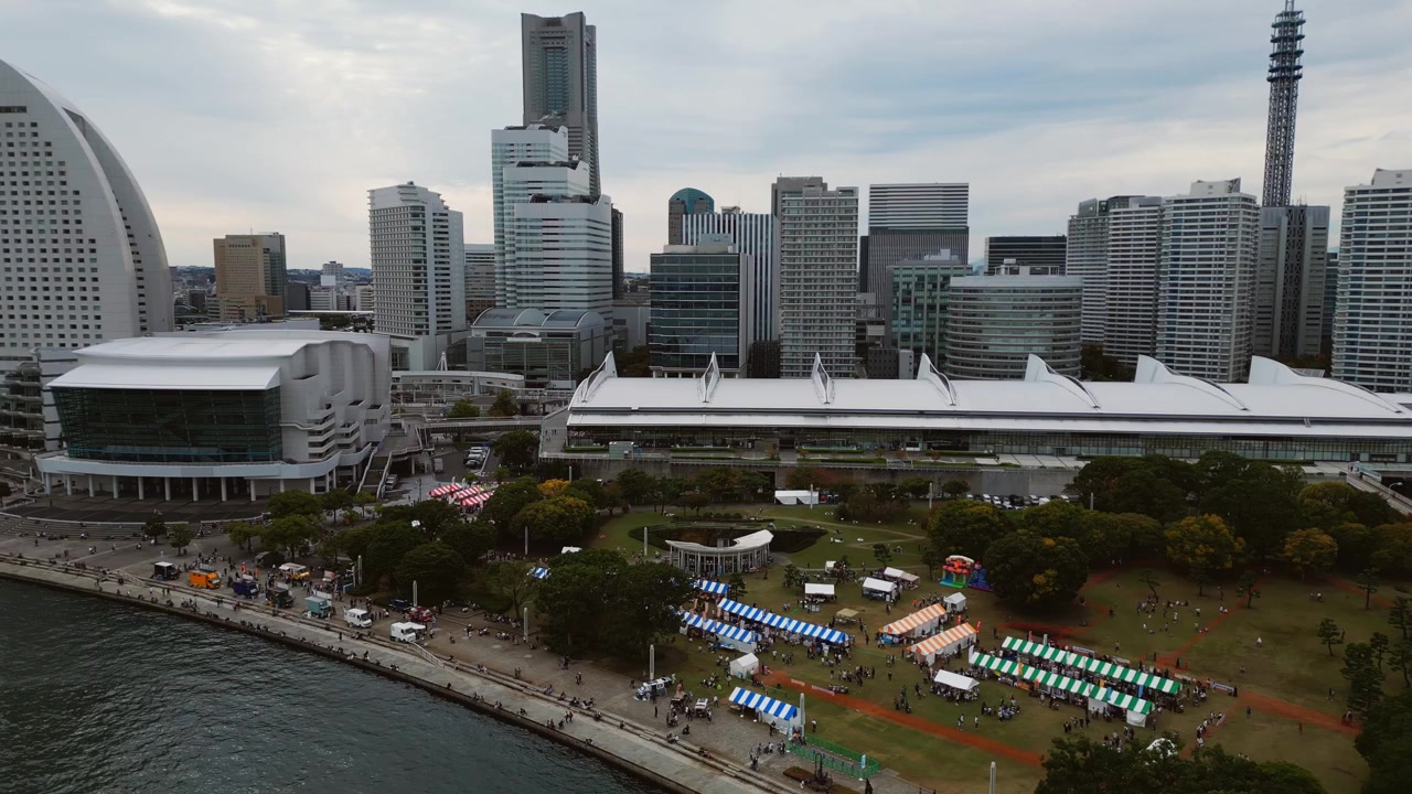 Moderno quartiere della baia di Yokohama con torri iconiche e aree per eventi.