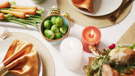 video of tray with roasted turkey, candles, plates and table decorated for thanksgiving dinner