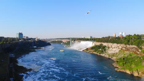 Dolly-Aéreo-Hacia-Las-Cataratas-Del-Niágara-Con-Un-Barco-Turístico-En-Su-Expedición