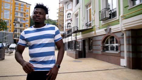 cheerful guy enjoying afrohouse music on street