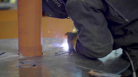 vista recortada de un soldador masculino en una mesa de metal de soldadura de equipo protector