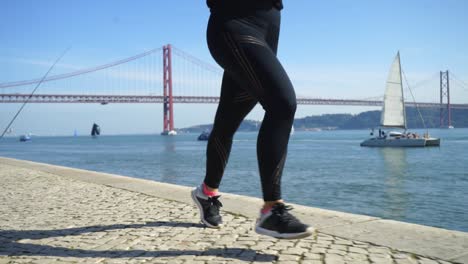 piernas de una joven deportista corriendo cerca del río