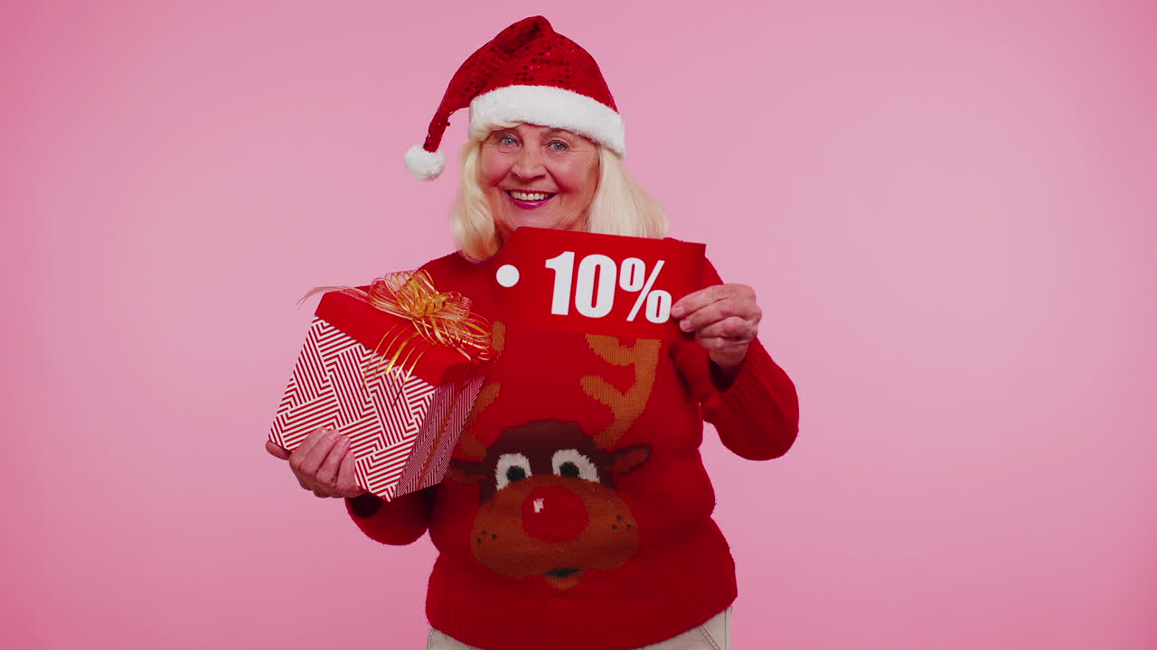 abuela en suéter de navidad mostrando caja de regalos y 10 por ciento de descuento inscripciones texto de pancarta