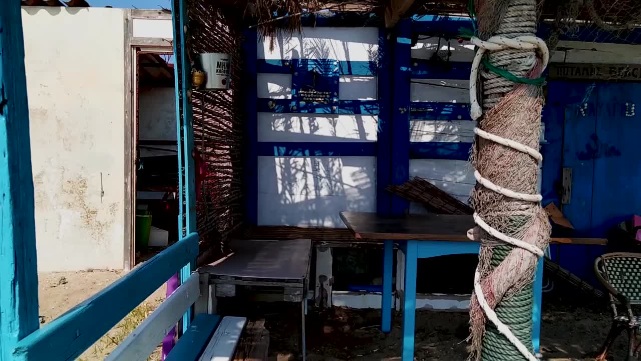 북부 그리스의 테살로니키 에파노미에 가까운 여름철 그리스 섬의 모래 해변에 있는 낚시 판잣집으로 해변을 따라 패닝 샷