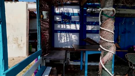 Paning-shot-following-the-beach-to-a-fishing-shack-in-a-sandy-beach-in-Greek-island-during-summer-time-close-to-Epanomi,-Thessaloniki-in-nothern-Greece