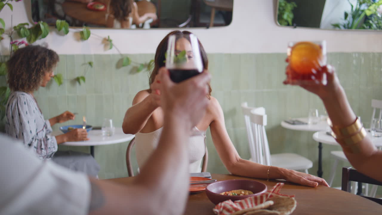 쾌활한 여성이 카페에서 잔을 는 친구들. 술을 마시는 사람들