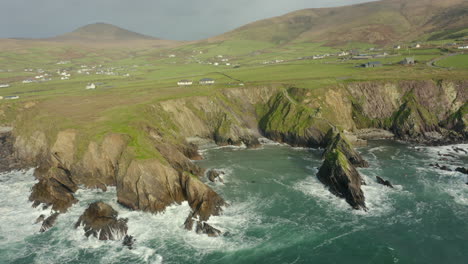 aerial drone view, waves crash against the rugged coastline in ireland