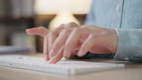 close up hand of a business woman typing keyboard desktop computer on desk office