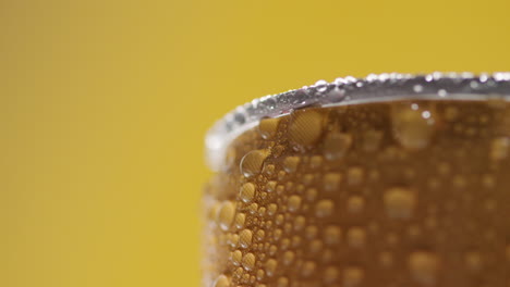 Close-Up-Of-Condensation-Droplets-On-Revolving-Takeaway-Can-Of-Cold-Beer-Or-Soft-Drink-Against-Yellow-Background-With-Copy-Space-1