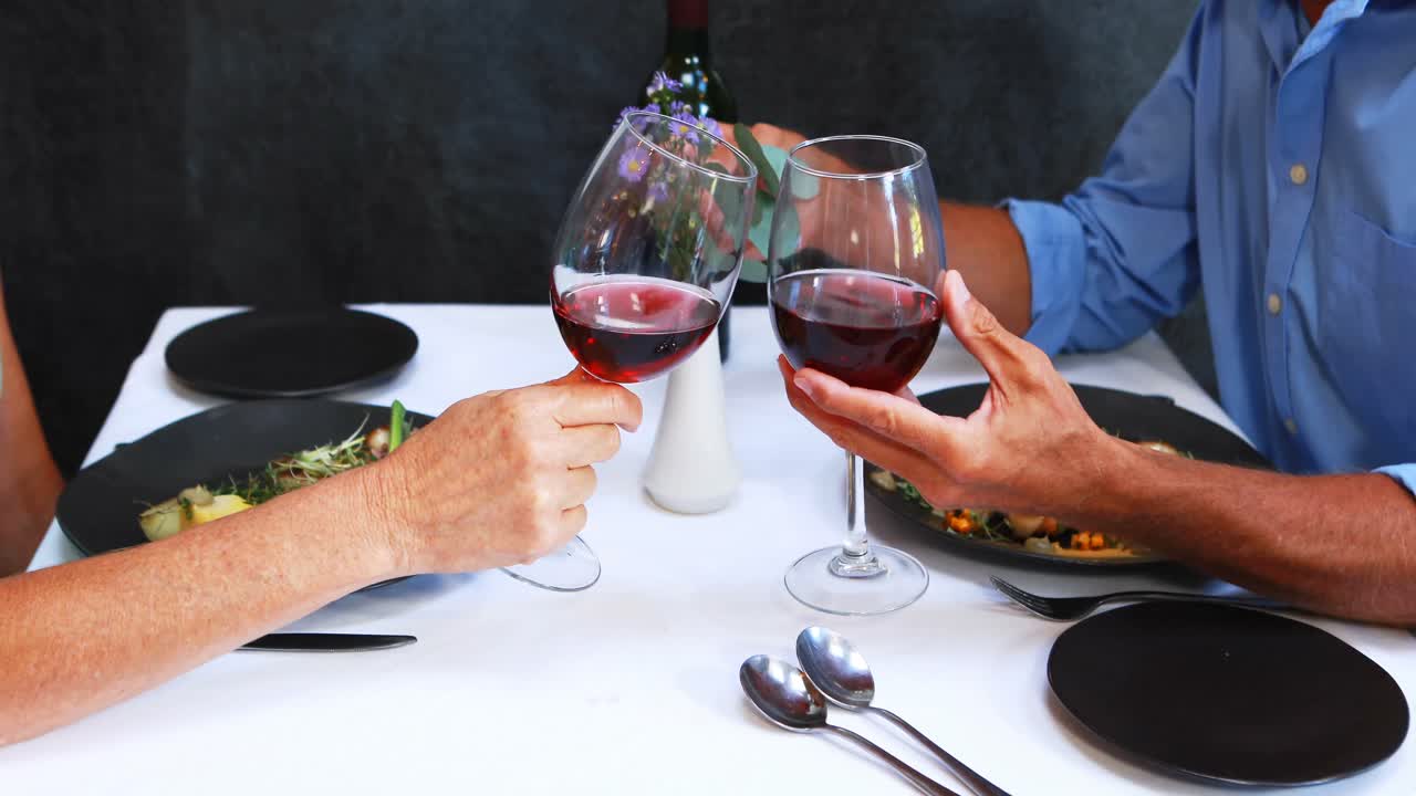 Pareja madura brindando con copas de vino
