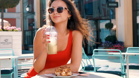 woman enjoying a drink and dessert in a cafe