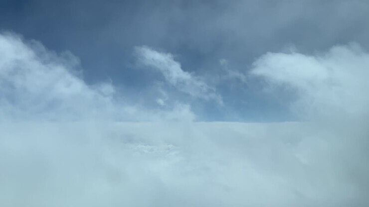 Flying through some frayed stratus clouds, shot from an airplane cabin while flying at cruise level of 12000m high