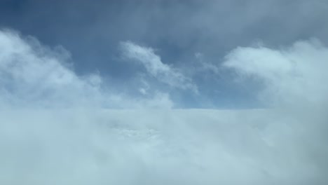 volando a través de algunas nubes de estrato desgastadas, disparado desde una cabina de avión mientras volaba a nivel de crucero de 12000 m de altura