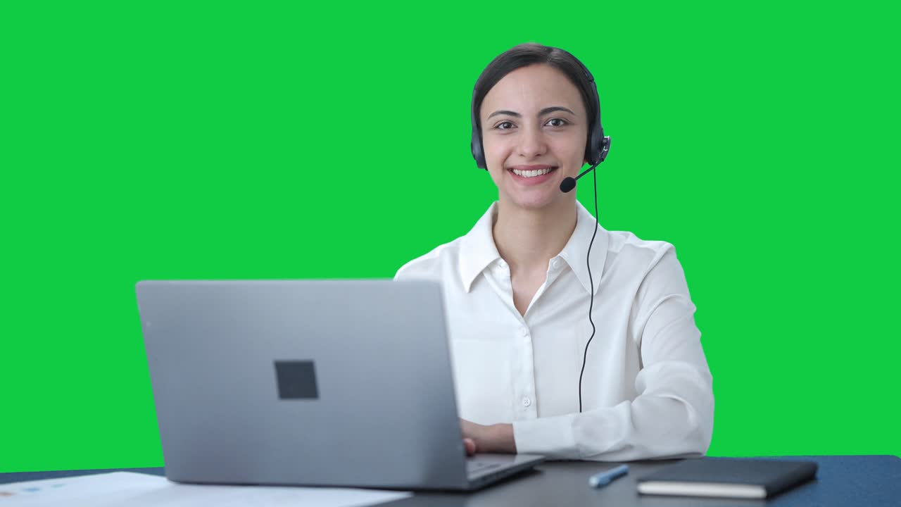 Operadora india feliz de centro de llamadas sonriendo. Pantalla verde.