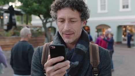 close up portrait of attractive mature caucasian man smiling browsing using smartphone texting app enjoying mobile technology