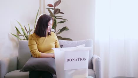 mujer asiática presionando el teléfono usando una tarjeta de crédito para pagar en línea para reservar la entrega de la caja de donación