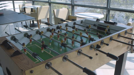 toma panorámica de una sala de juegos de oficina vacía con tenis de mesa y futbolín