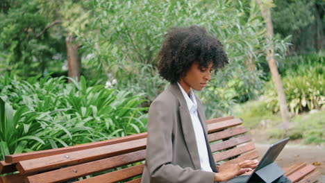 Mujer-Independiente-Sentada-En-Un-Banco-Escribiendo-En-Una-Computadora-Portátil-De-Cerca.-Señora-Haciendo-Trabajo-Remoto.