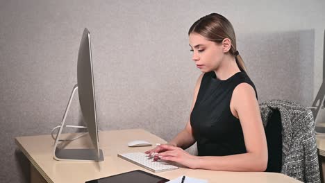 mujer joven feliz freelance que trabaja en la computadora en la oficina. mujer de negocios atractiva que estudia en línea, usando software de portátil, información de navegación en la web o compras en la tienda de internet