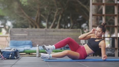 woman exercising outdoors on a yoga mat