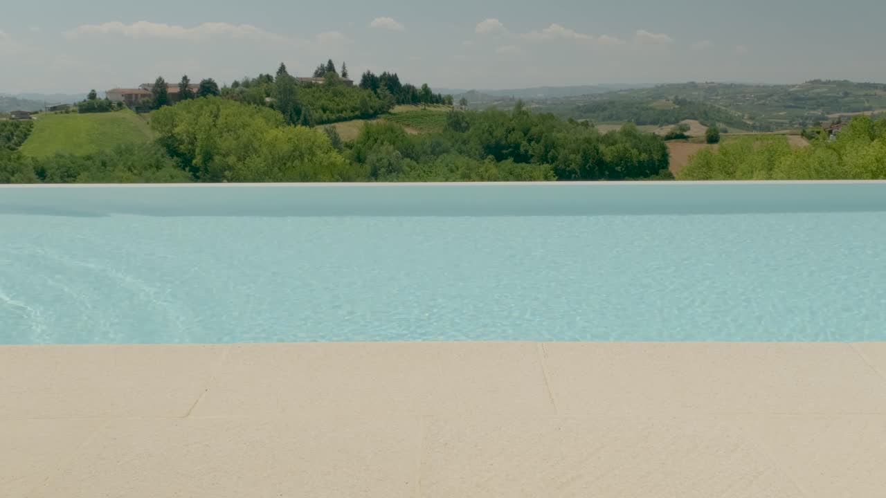 Nahaufnahme einer Frau, die vor einem ländlichen Pool aus dem Wasser kommt.