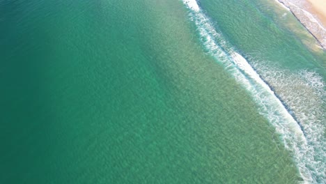 turquoise sea waters with waves splashing at kawana beach in queensland, australia