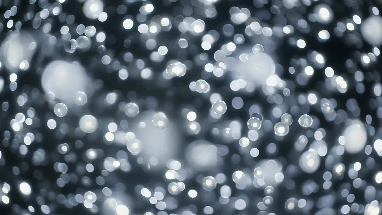 Luce fredda e costante che colpisce le goccioline, creando riflessi sfocati e macchie morbide che si muovono in una macroscopia scura