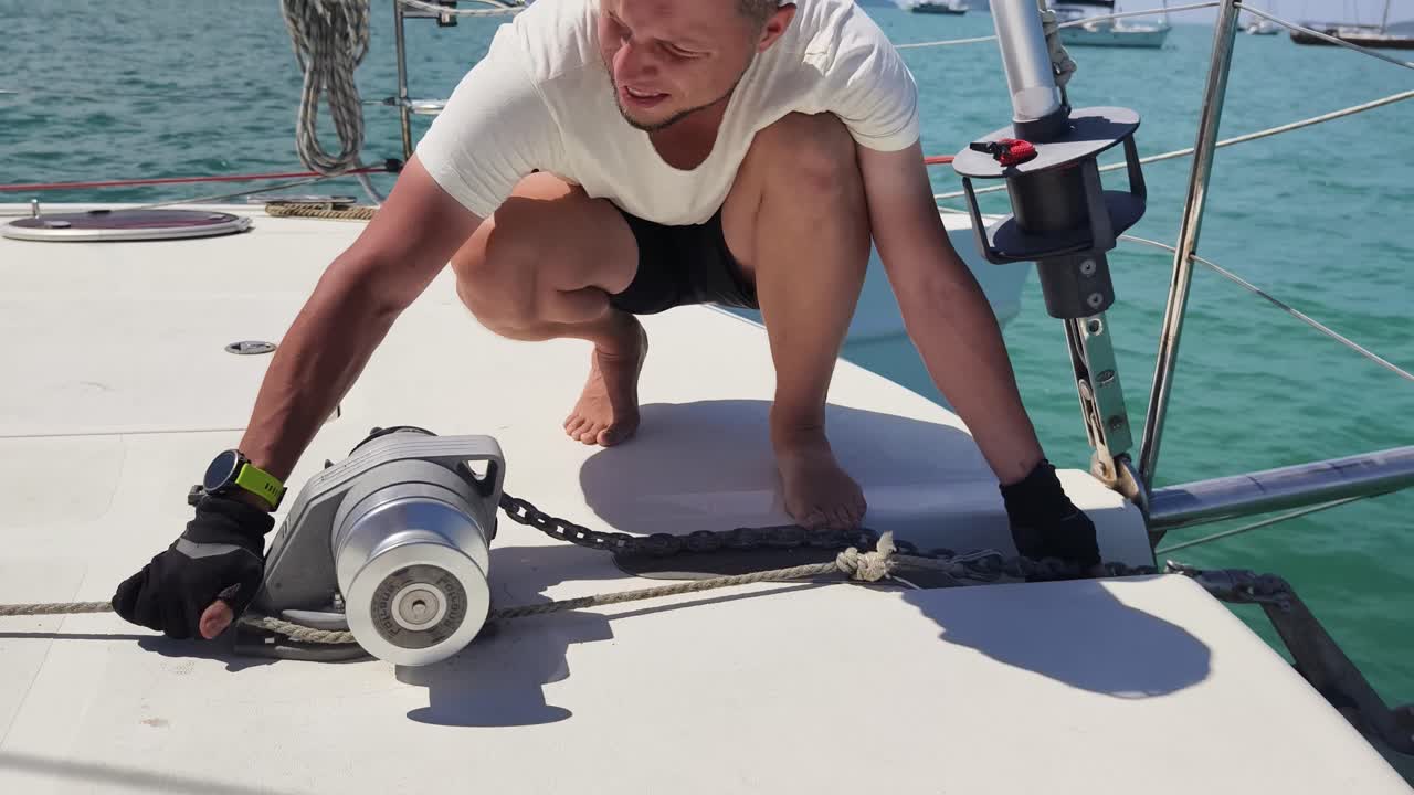 marinero trabajando en la cubierta del catamarán
