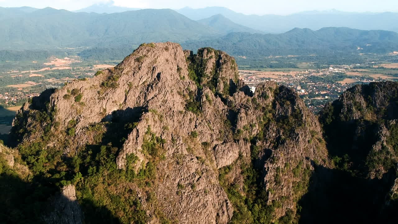 en la cima de una montaña durante la puesta de sol en laos con una vista increíble del paisaje verde y arenoso