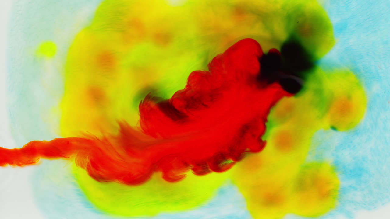 disparo aéreo de gotas de pintura o tinte multicolor mezcladas en agua para crear un patrón de colores giratorios