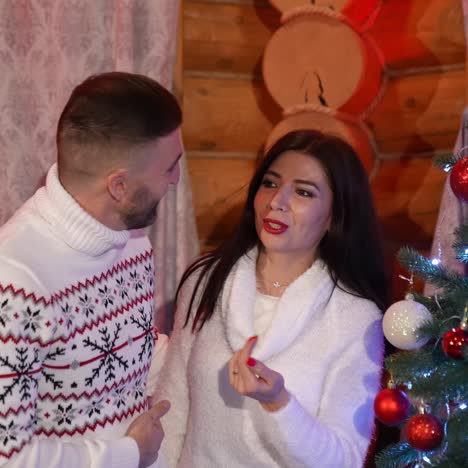 couple in love near christmas tree. happy couple standing near christmas tree at home