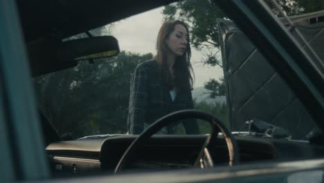 woman checking broken down car