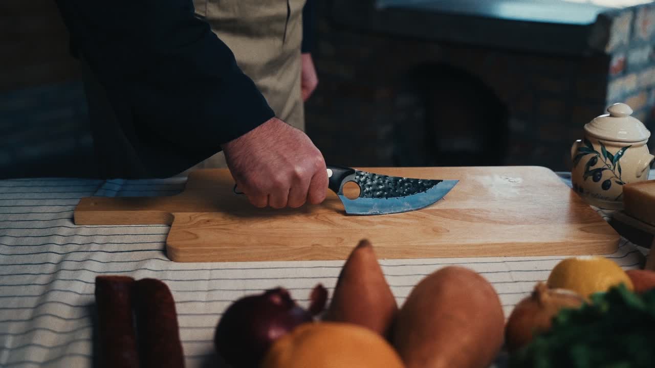 la mano de un chef agarra un cuchillo rústico en una tabla de corte, preparación de alimentos en una cocina acogedora