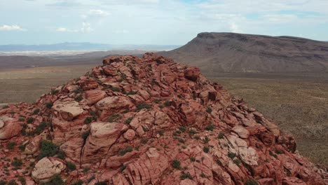 toma aérea panorámica de un pico de montaña rocosa con rocas rojas en medio del desierto