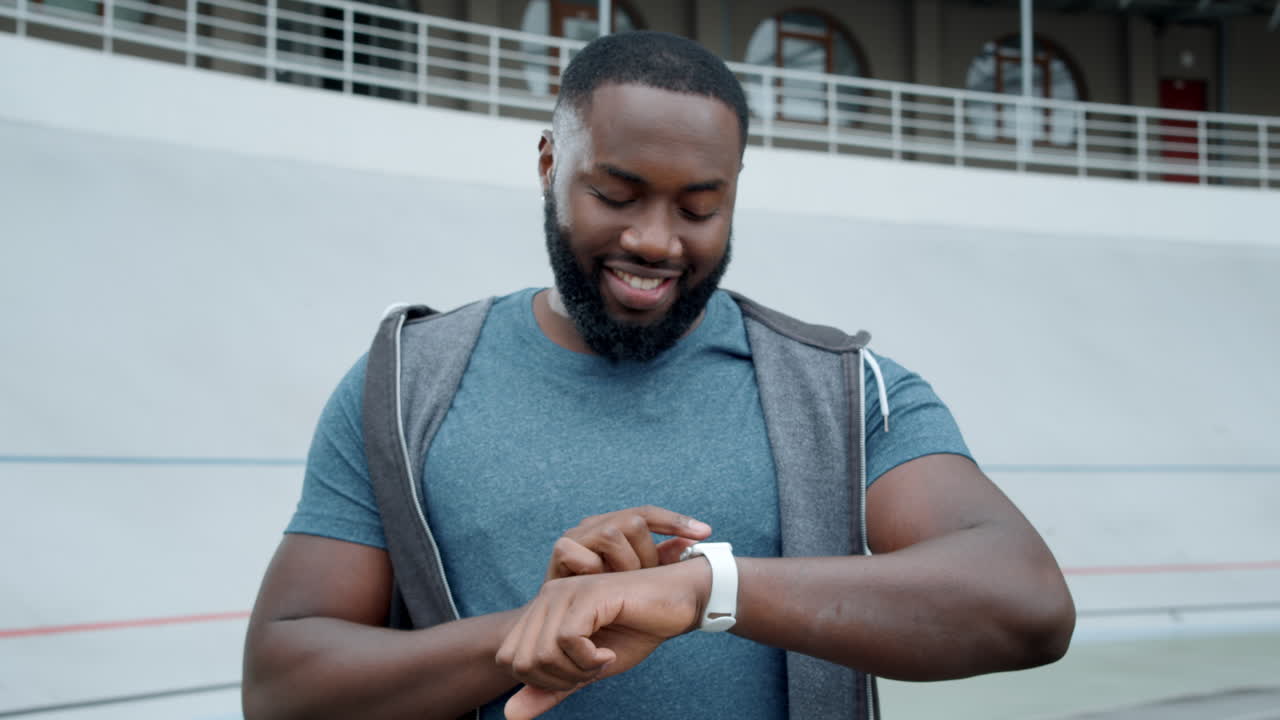 un tipo usando un reloj inteligente al aire libre.