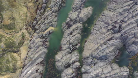 Hermoso-Patrón-De-Roca-Entre-Pequeños-Lagos-De-Agua-Verde