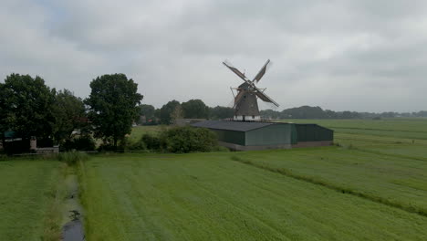 aerial dolly of scaffolding wind mill in a small dutch town