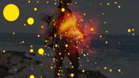 woman hiking on rocky coastline, with health data graphics showing glowing sparks and red flames