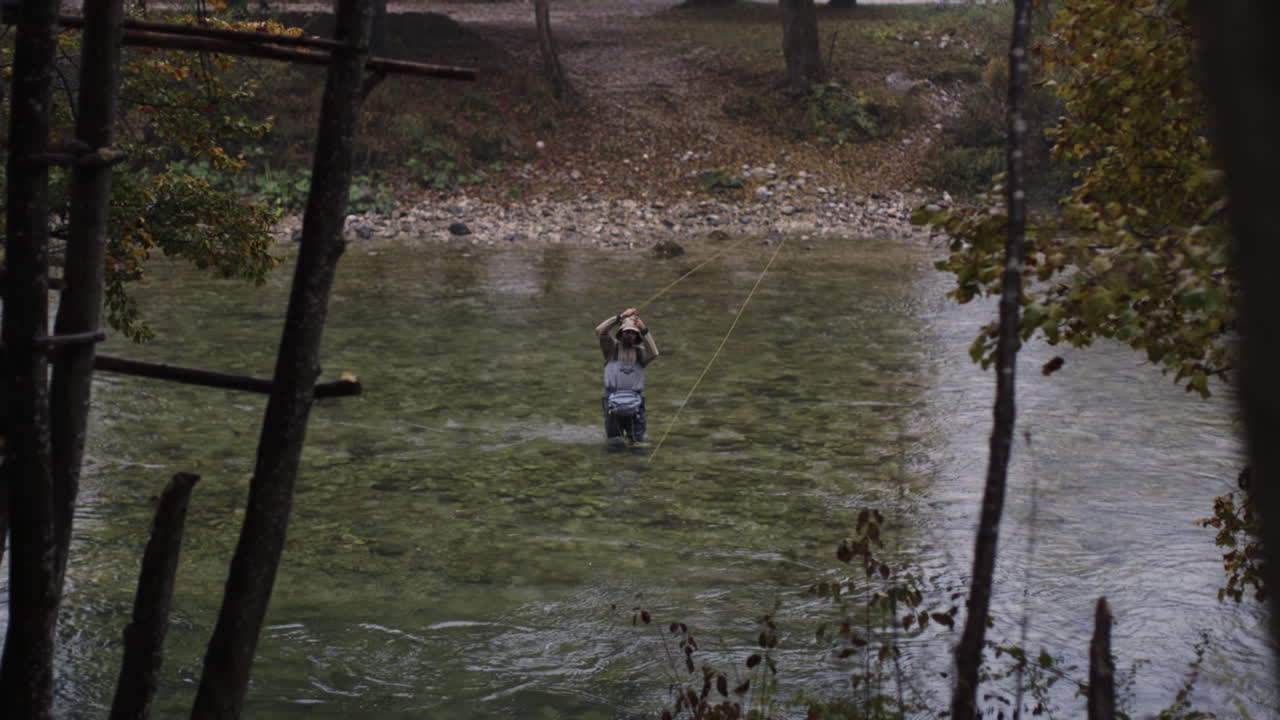 Pesca a mosca in un fiume boschivo autunnale