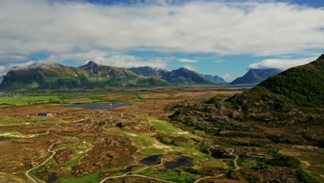 Aerial drone the over the picturesque landscape of the Lofoten Islands in Norway. High view of the green mountains, vast landscape and the blue Norwegian sea. Breathtaking nordic landmark.