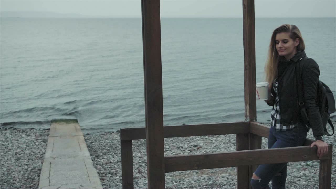 mujer disfrutando de café en la playa